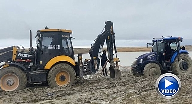 Çamura saplanan traktör kepçe ile kurtarıldı